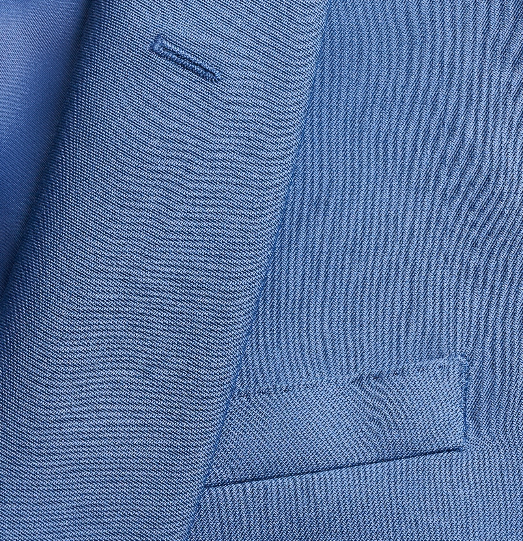 Close-up of a blue suit jacket fabric and pocket.