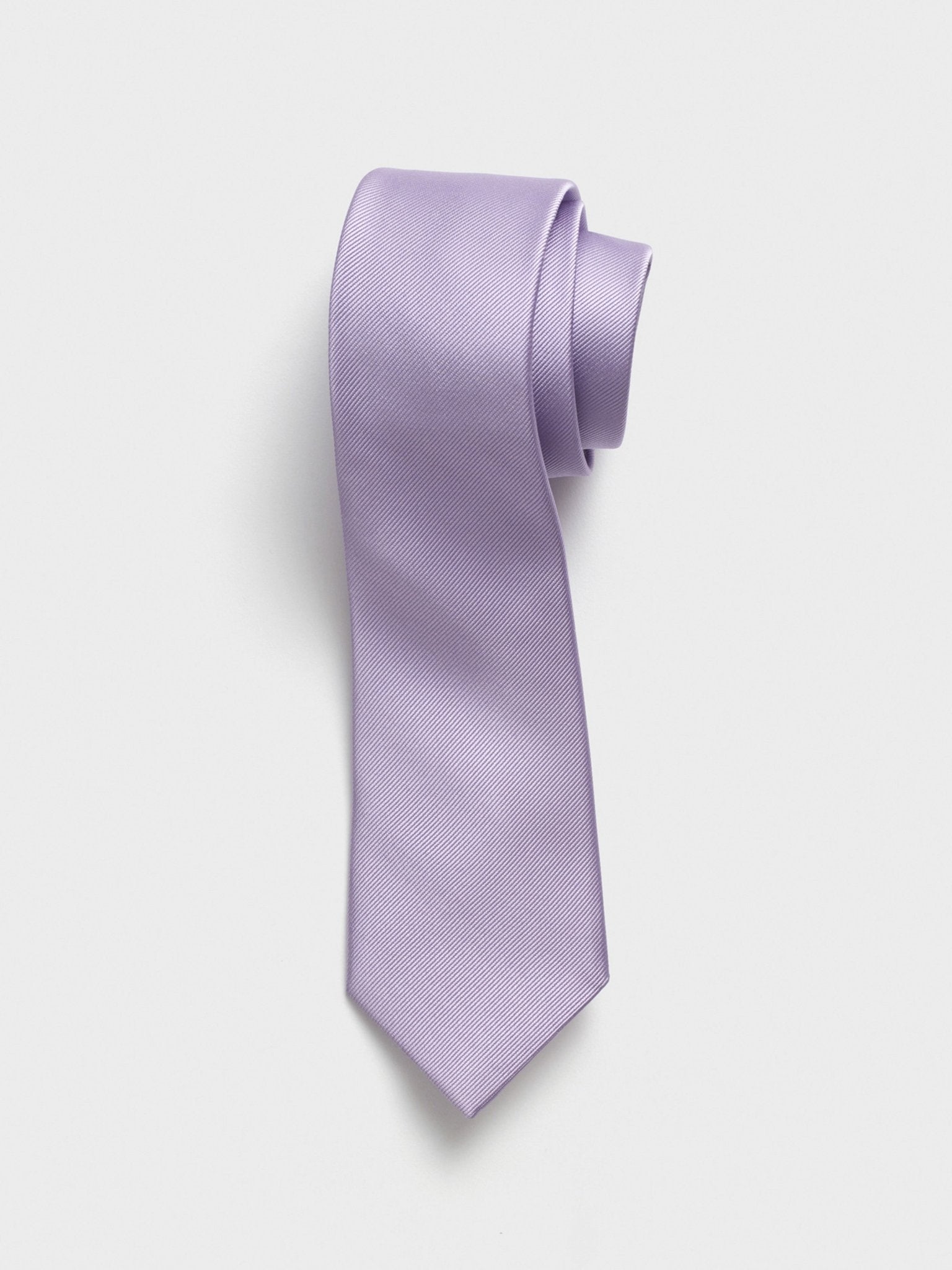 Light purple tie rolled up on a white background.