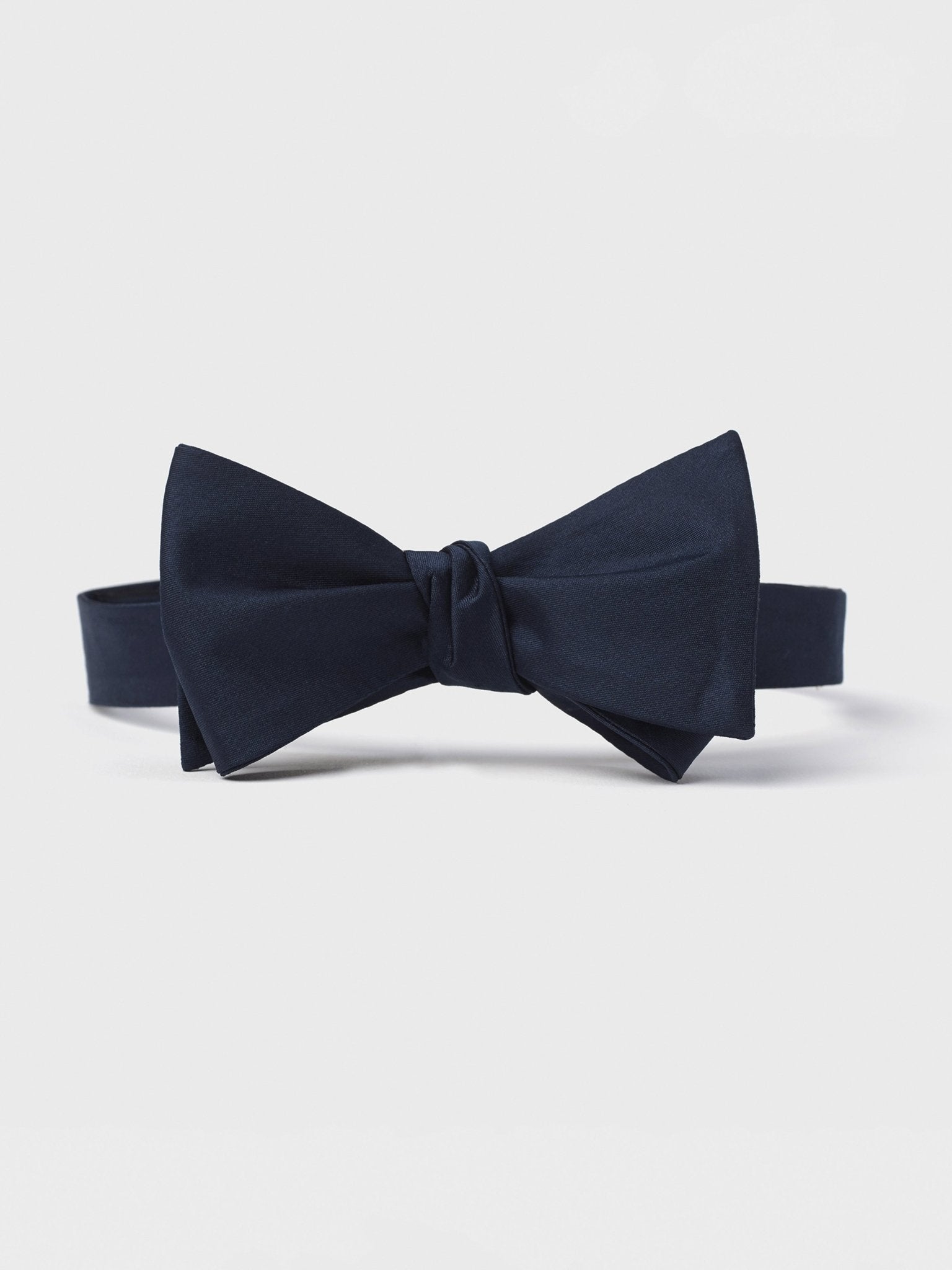Navy blue bow tie on a white background.