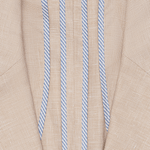 Close-up of a tan fabric with blue and white striped details.