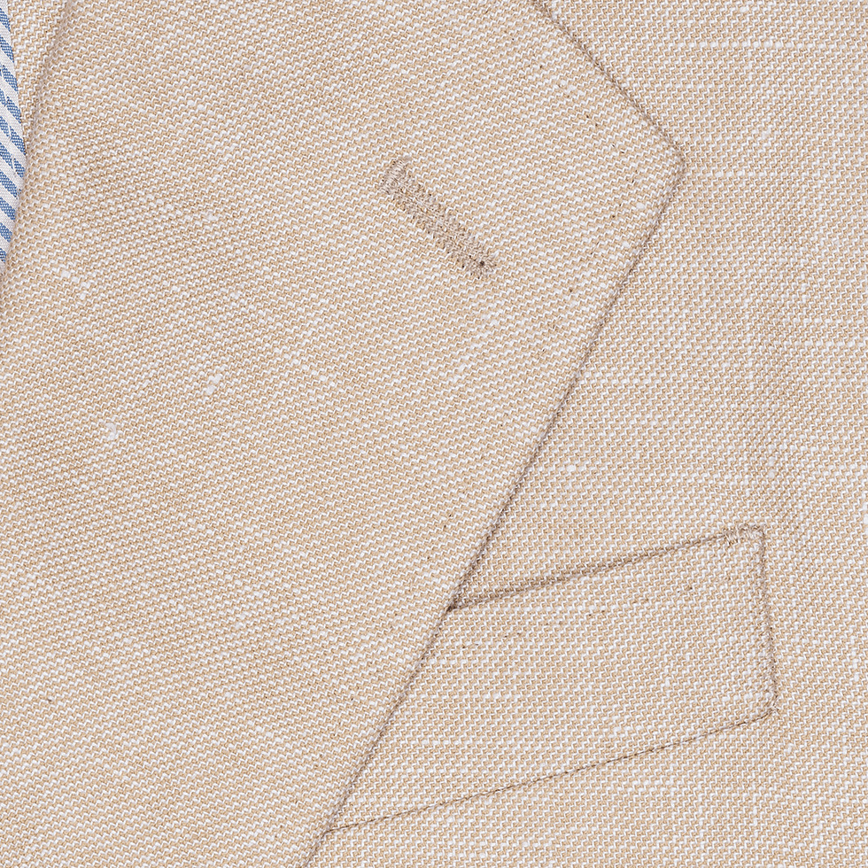 Close-up of a tan suit jacket with a blue and white striped shirt collar.