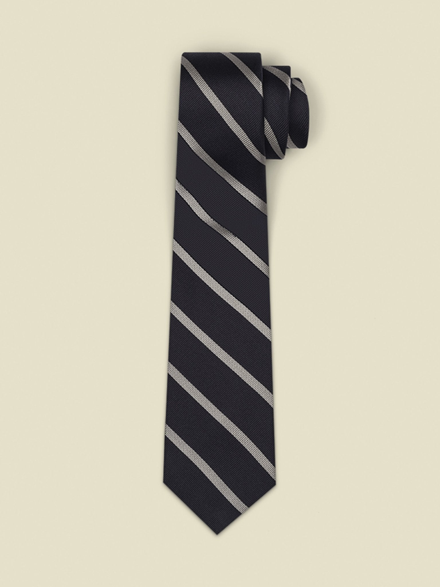 Navy tie with silver diagonal stripes, rolled up on a light background.