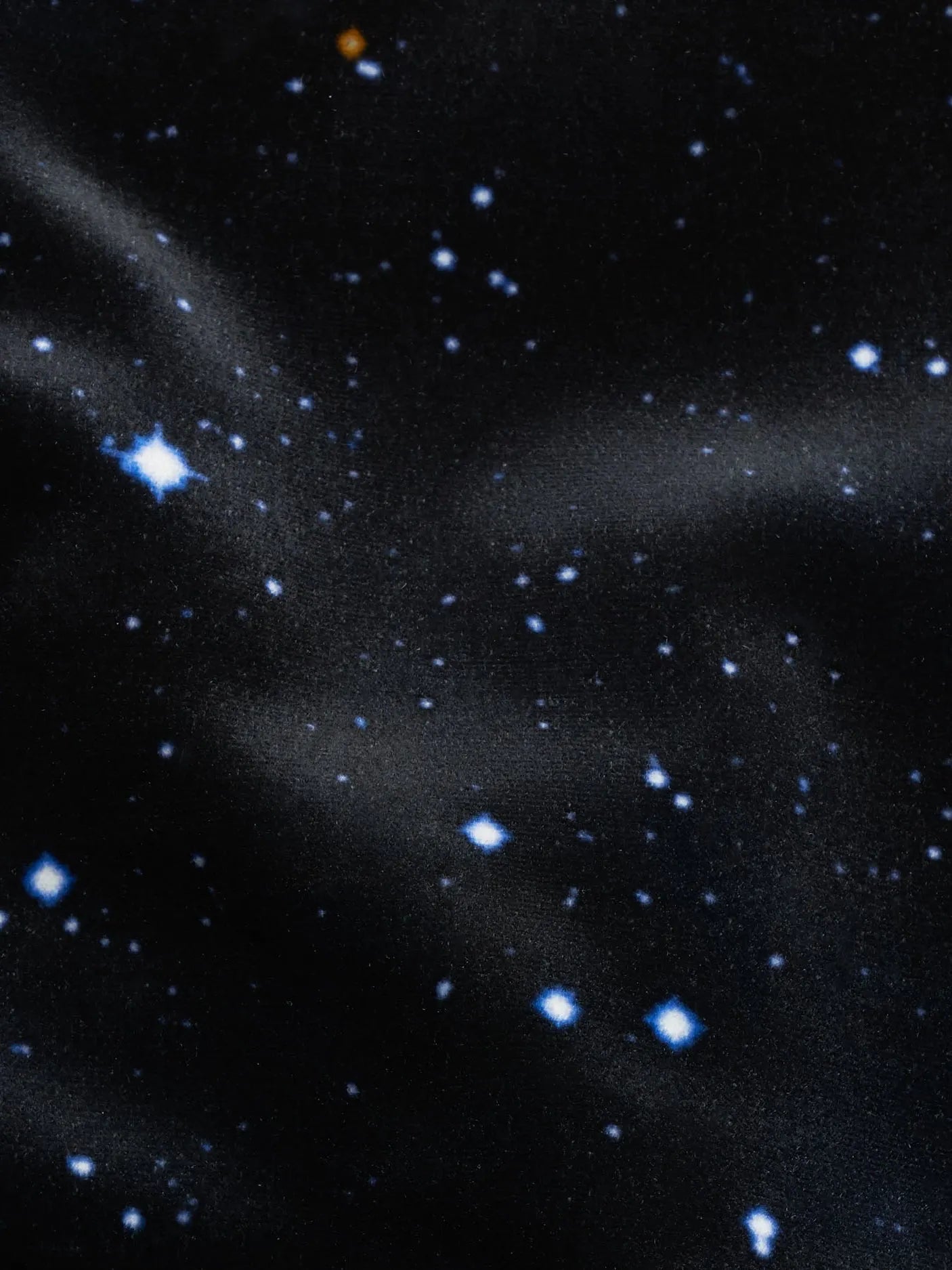 Fabric with a starry night pattern featuring various stars on a black background.