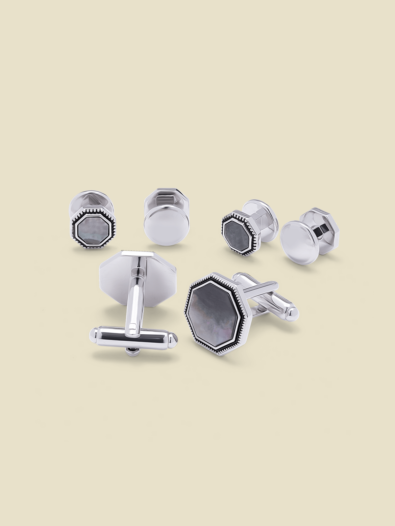 Various silver cufflinks displayed on a light beige background.