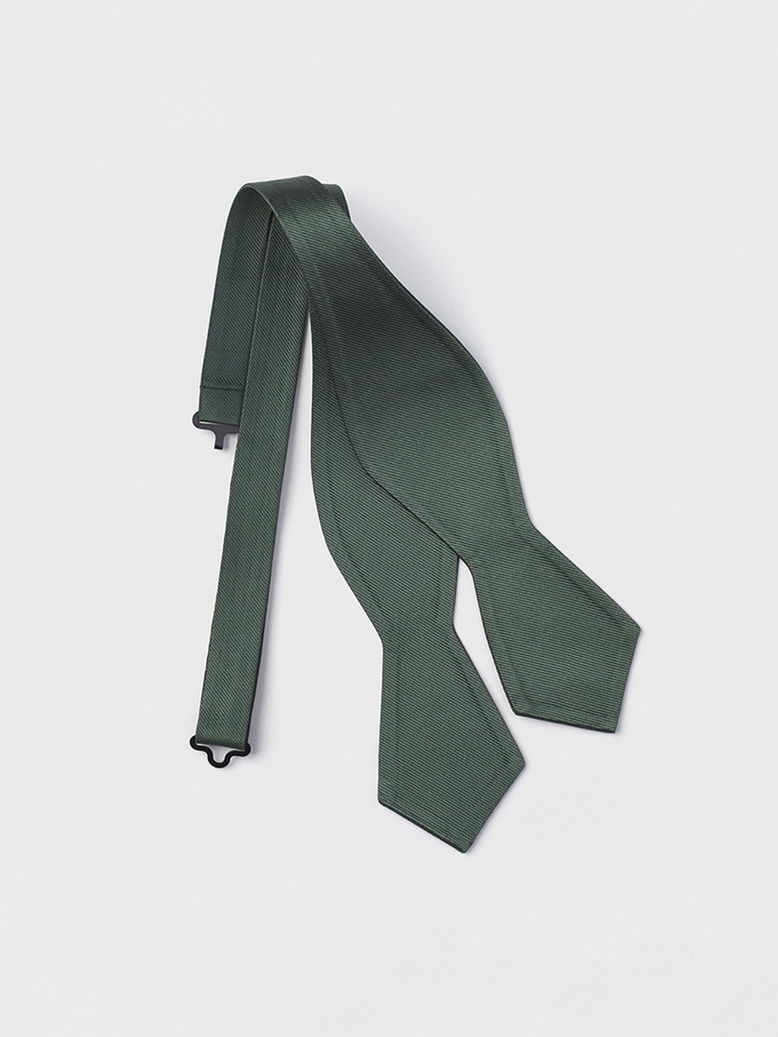 Dark green bow tie with a textured pattern, laid flat on a white background.