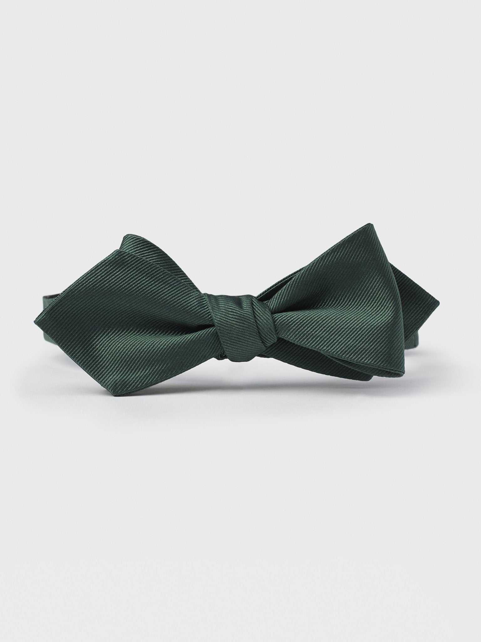 Dark green bow tie with a textured finish on a white background.