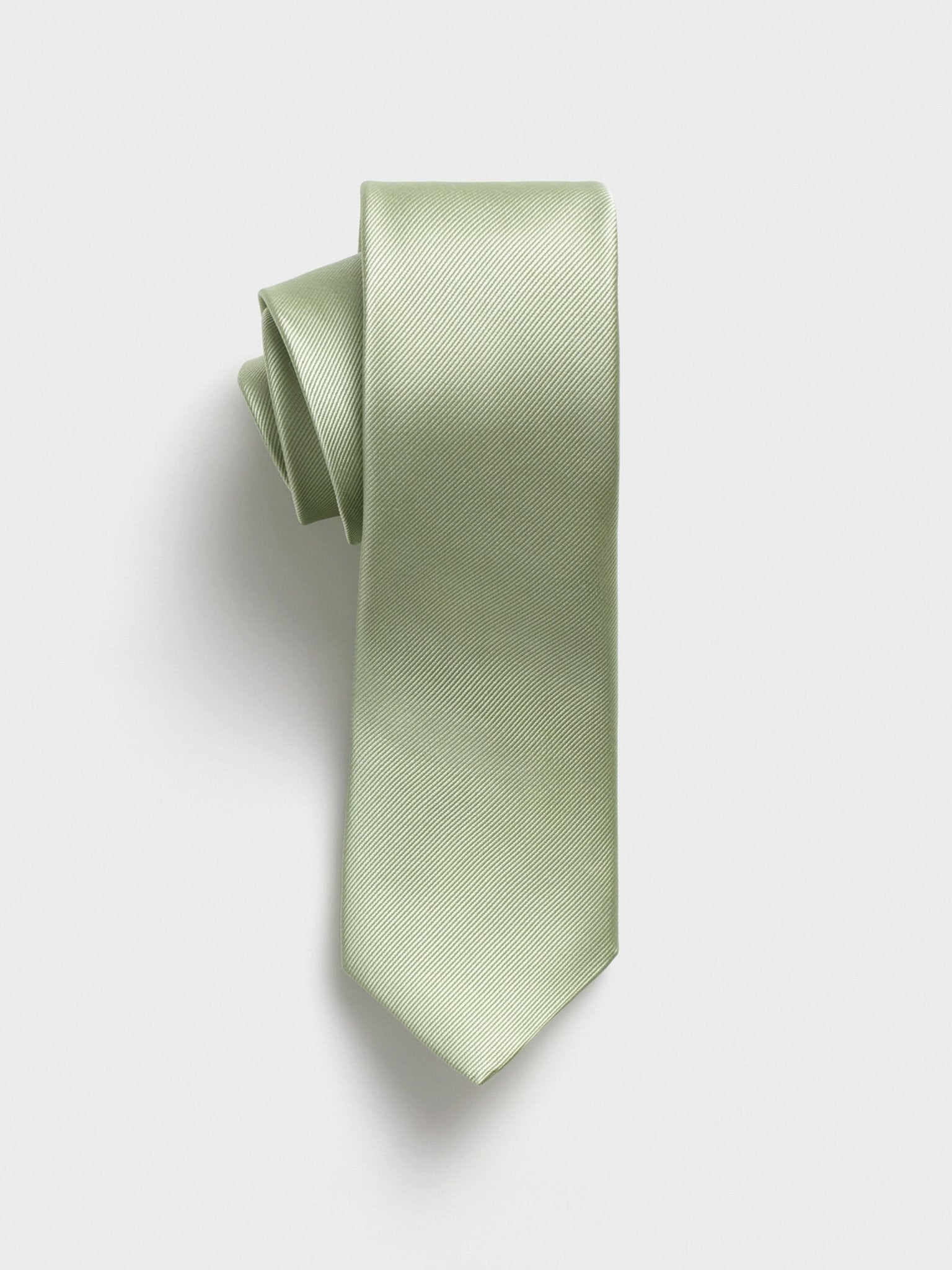 Light green tie with a textured pattern, rolled up on a white background.