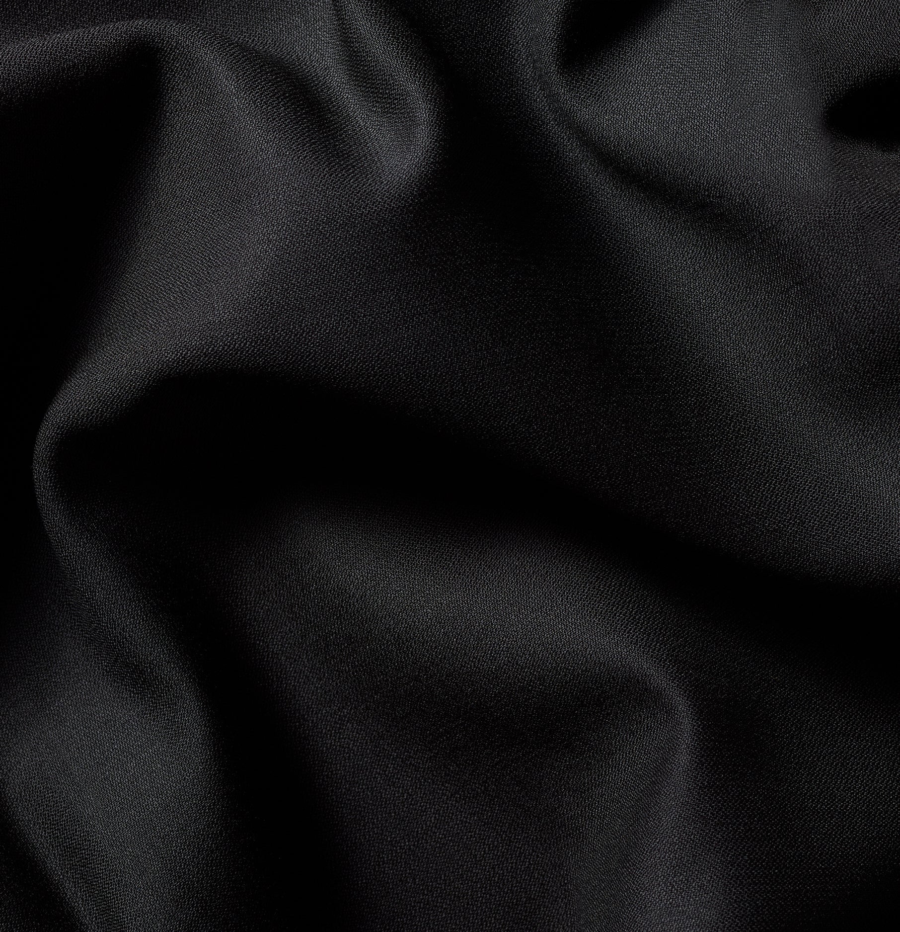 Close-up of black fabric with soft texture and folds.
