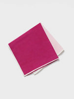 A folded pocket square in magenta with a white border.