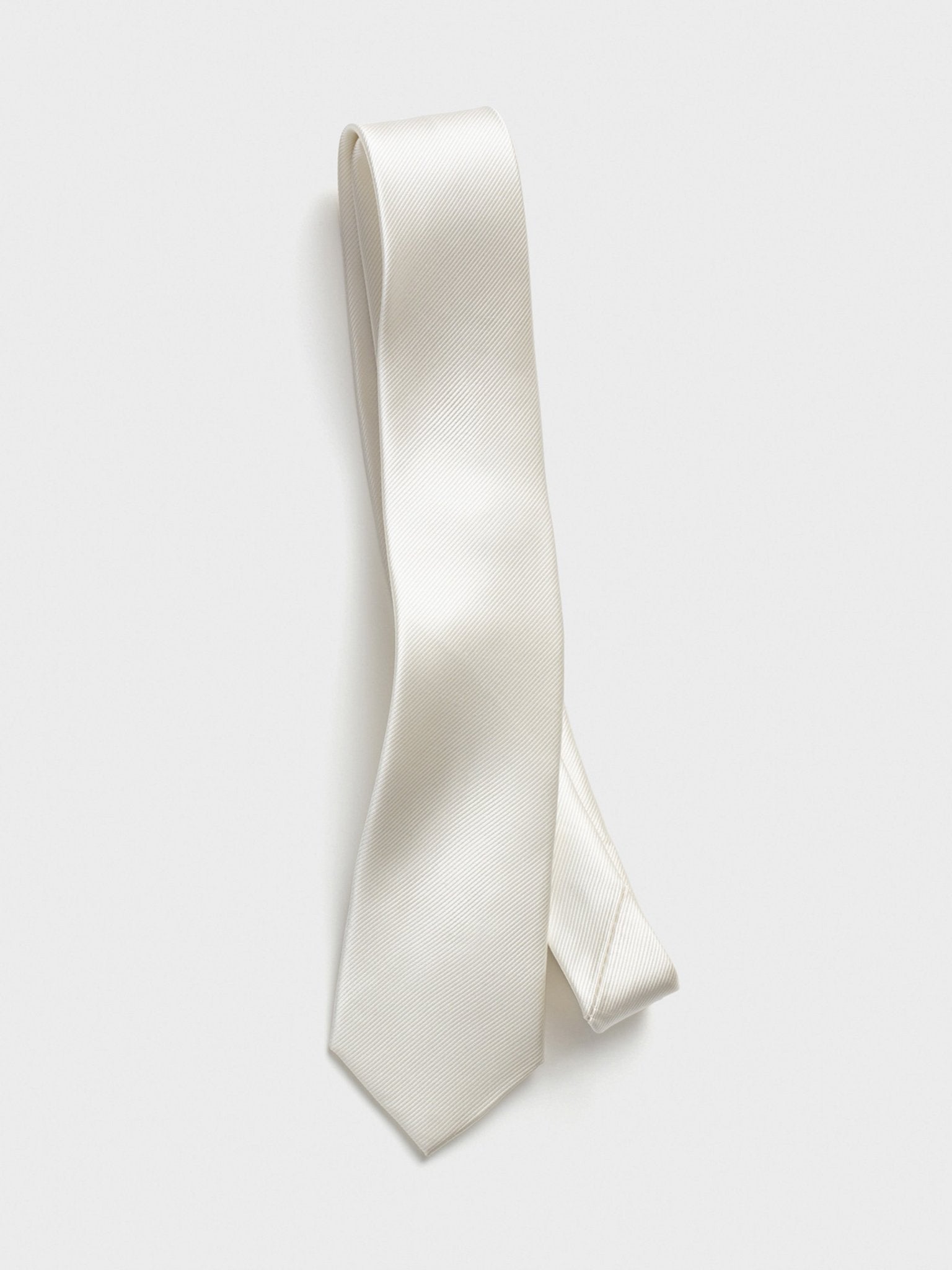 A white tie with a ribbed texture displayed against a light background.