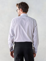 Man wearing a white shirt and black pants, viewed from the back.
