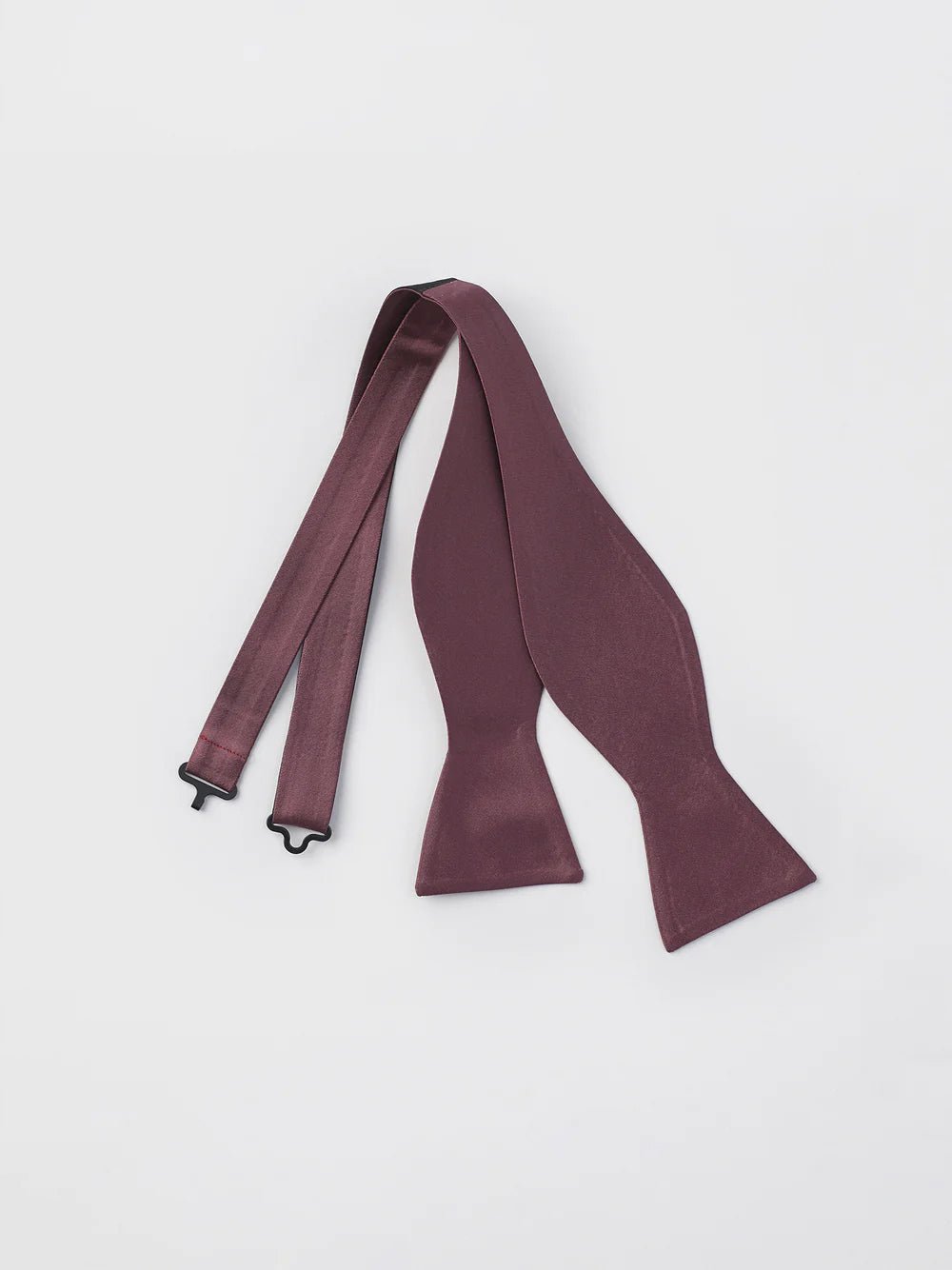 Burgundy bow tie with adjustable straps laid flat on a white background.