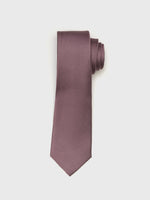 A rolled-up purple tie with a textured pattern on a white background.