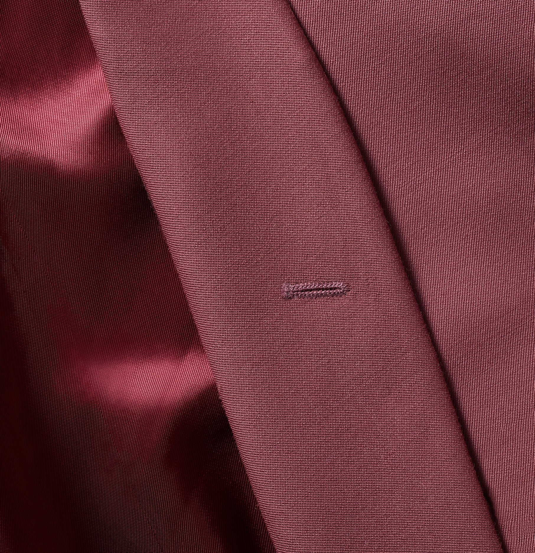 Close-up of a maroon fabric with a small stitched label.