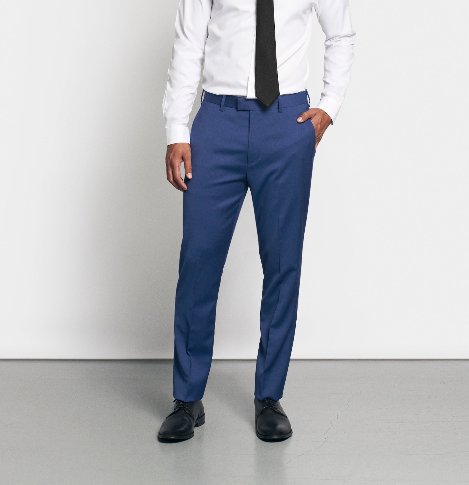 Man wearing a white shirt, black tie, and blue dress pants.