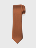 Brown textured tie rolled and resting on a white background.