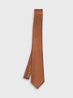 Solid brown tie with a textured pattern, hanging vertically against a white background.