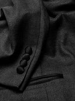 Close-up of a black tuxedo jacket showing fabric texture and buttons.