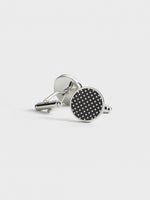 Silver cufflinks with a black circular design and white polka dots.
