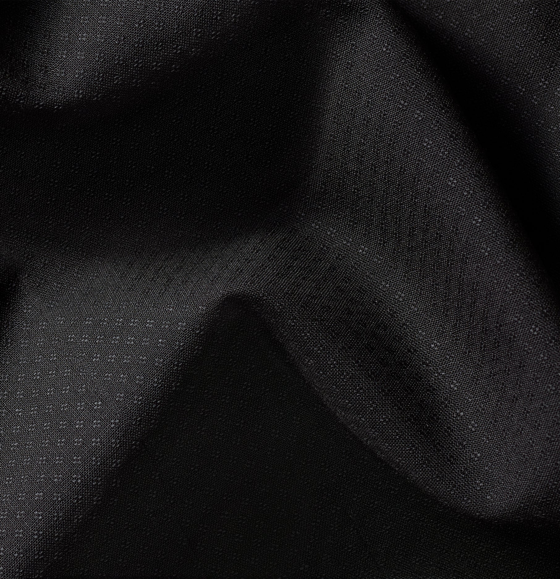 Close-up of black textured fabric with subtle patterns.