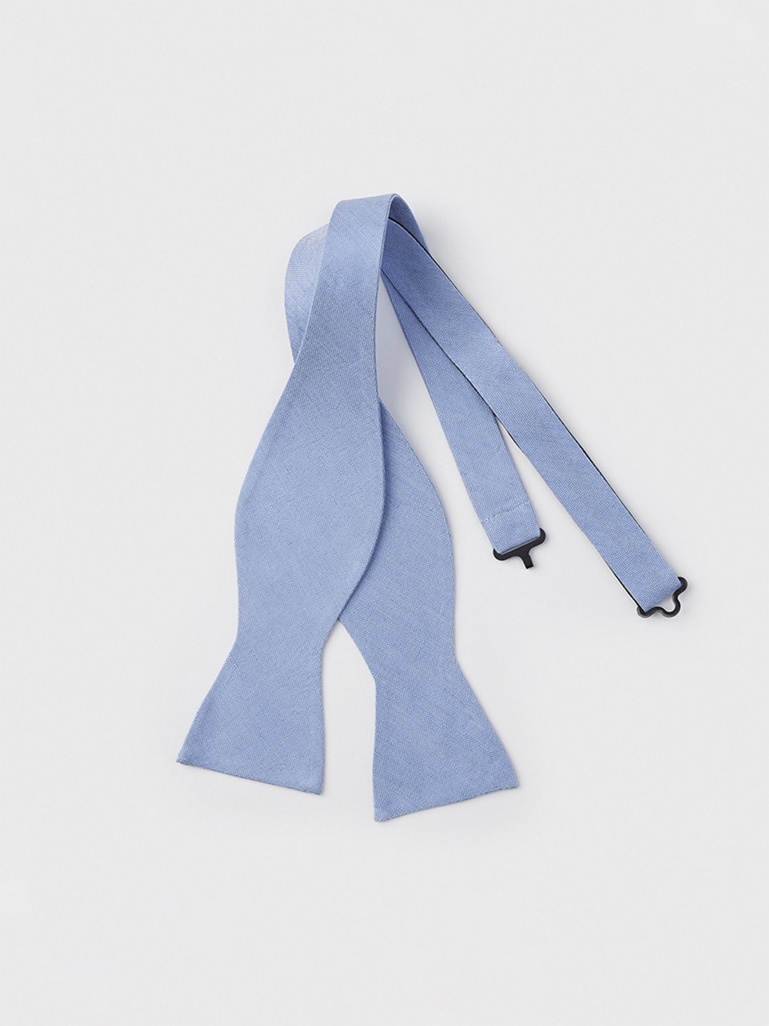 Light blue bow tie with adjustable straps on a white background.
