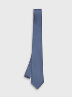 Blue tie with white polka dots on a plain background.