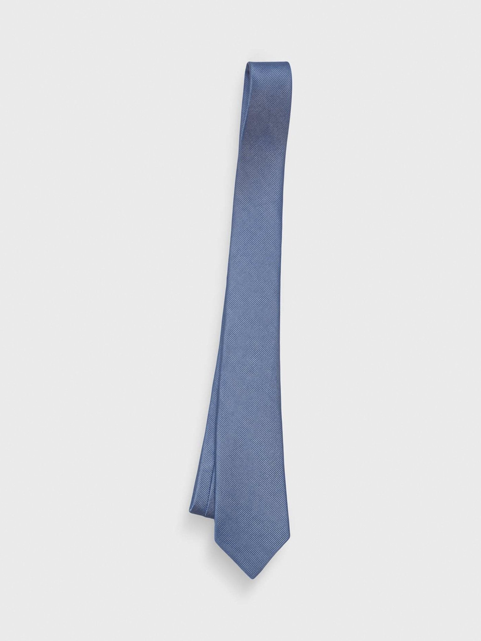 A blue tie hanging against a white background.
