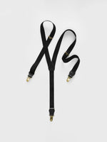 Black suspenders with gold clips on a white background.