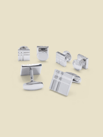 Various silver cufflinks arranged on a light beige background.