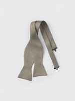 A light grey bow tie with an adjustable strap on a white background.