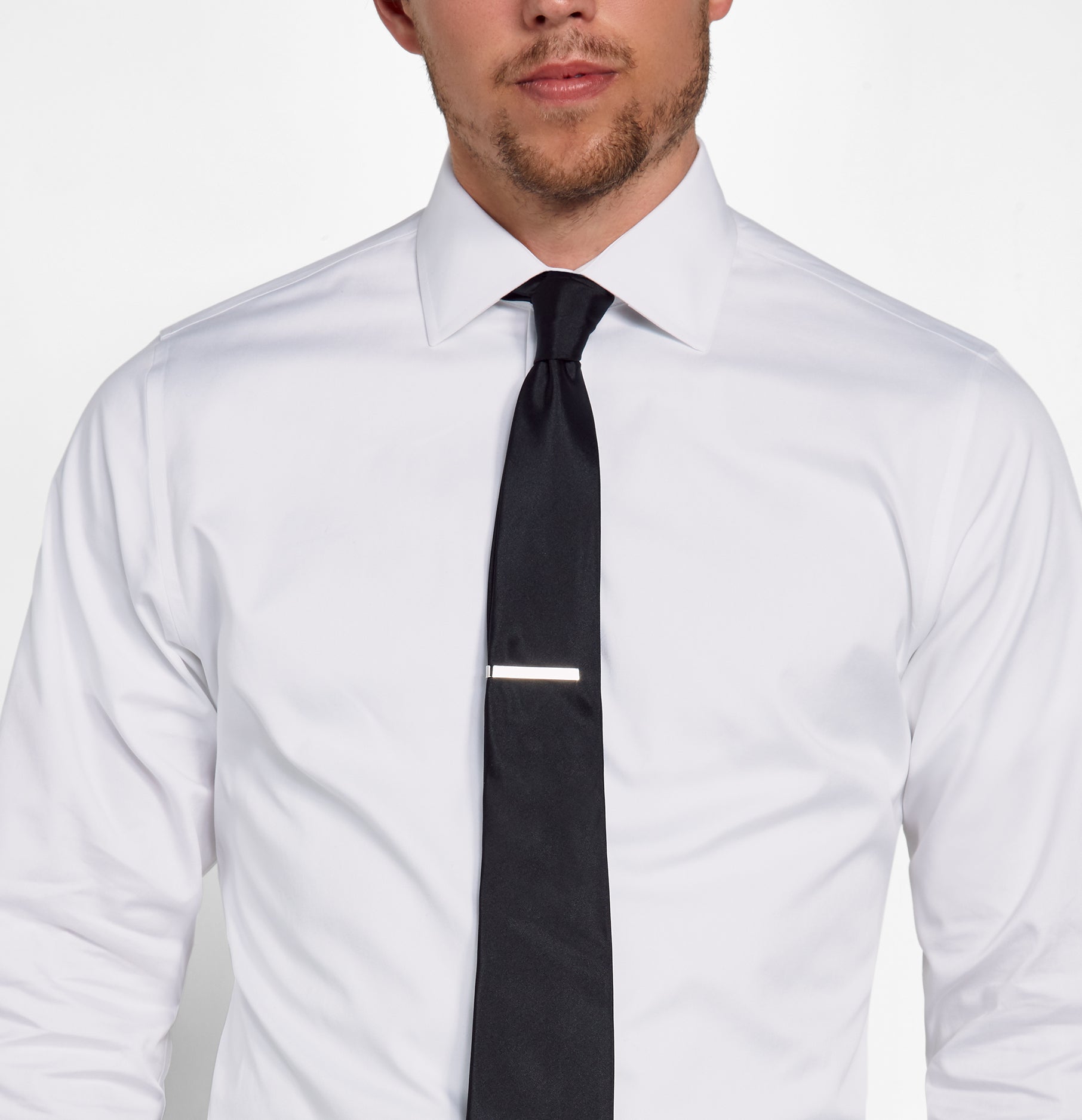 Man wearing a white dress shirt with a black tie and tie clip.
