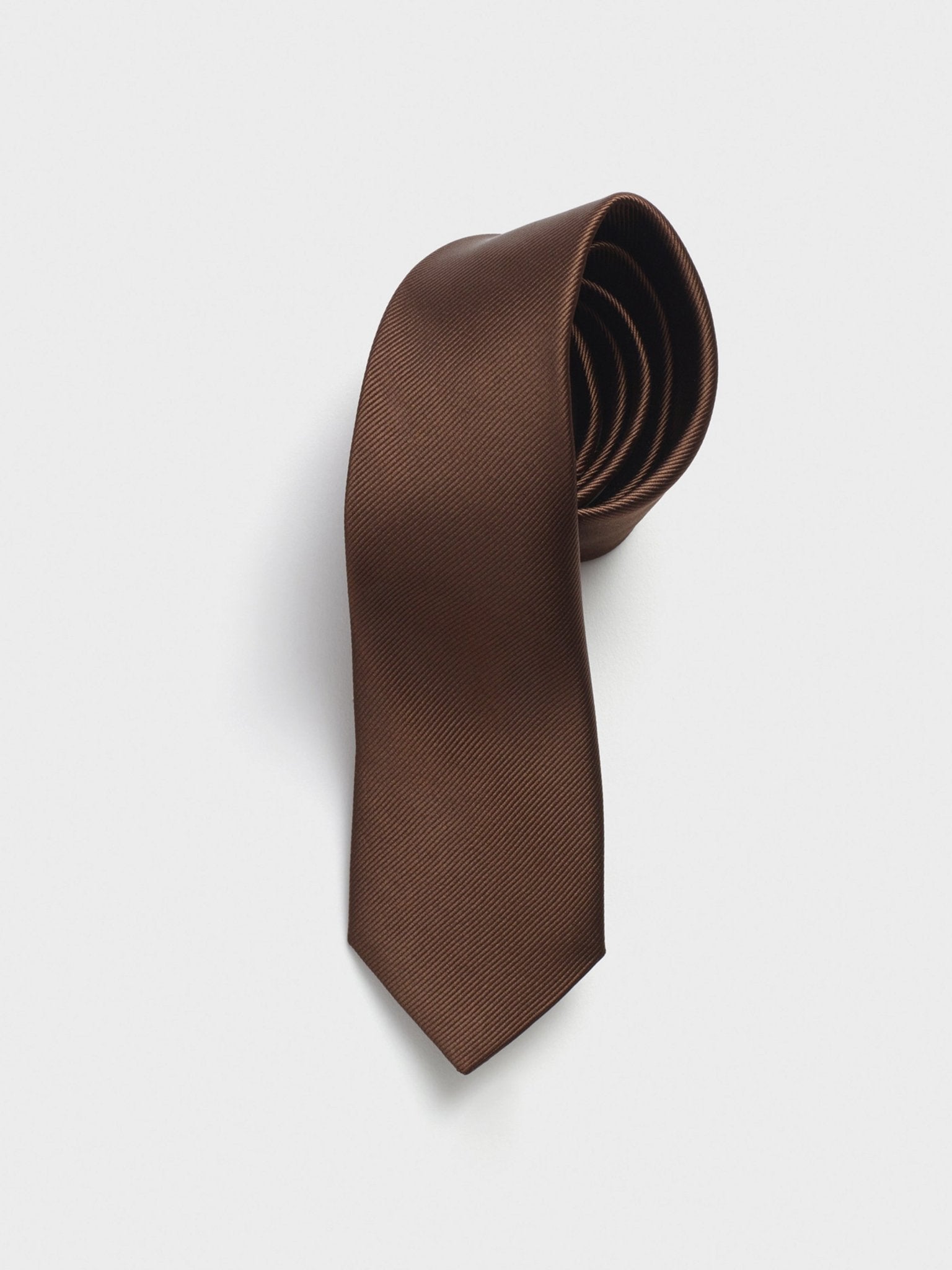 Brown tie with a textured pattern, coiled neatly.